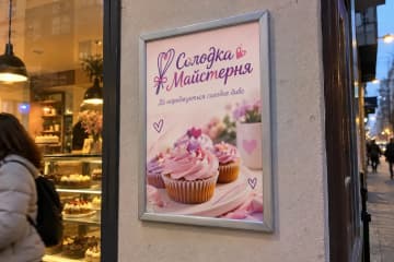 Клік-рамка з постером на стіні біля входу в кондитерську