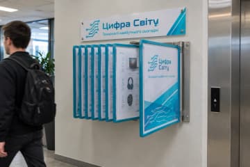 Перекидна система з блакитними рамками на стіні біля ліфта в офісі