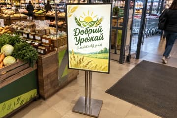 Світловий меню-стенд біля входу в продуктовий магазин