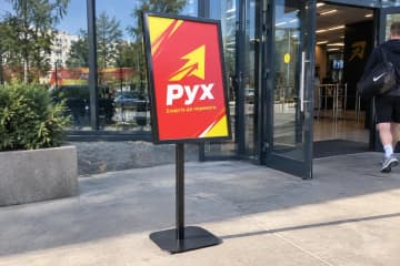 Меню-стенд на тротуарі біля входу в спортзал