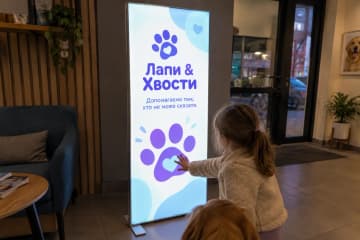 Вертикальний лайтбокс у ветклініці, дитина торкається полотна