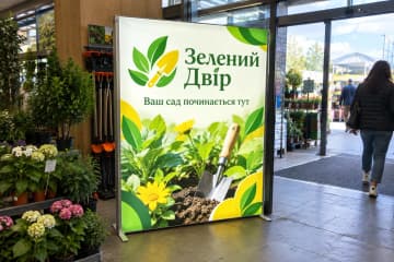 Мобільний лайтбокс у садовому центрі серед рослин