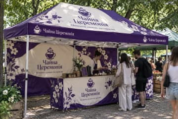 Шатер з друком і брендованим прилавком на ярмарку в парку