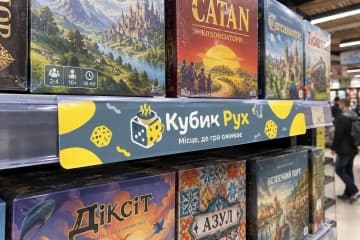 Шелфтокер на полиці з настільними іграми