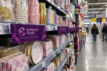 Шелфтокери на полицях зі святковим посудом у гіпермаркеті