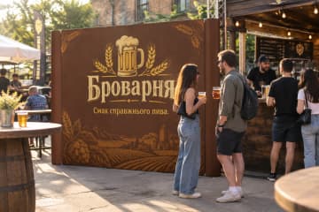 Строга пряма поп-ап стіна Поп-ап Line розміром 290×230 см стоїть на міському крафтовому фестивалі біля барної стійки.