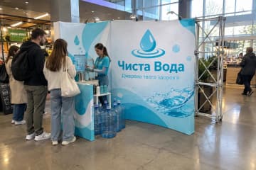 На сімейному ярмарку біля фуд-корту розміщено кутовий поп-ап MultiForm заввишки близько 226 см із суцільним друком для Чиста Вода.