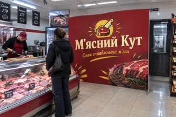 Прямий текстильний поп-ап 305×230 см для бренду «М'ясний Кут» у м’ясній крамниці поруч із холодильними вітринами та прилавком.