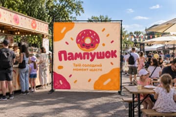 Брендвол Prime для «Пампушок» стоїть на сімейному фестивалі біля кіоску з пончиками.
