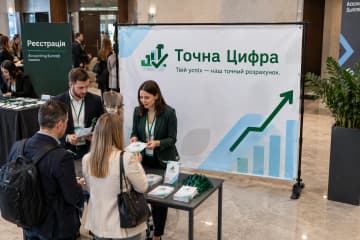 Брендвол Prime розміром 300×200 см для «Точна Цифра» стоїть у фойє бізнес-конференції біля реєстрації.