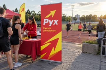 На спортивному заході клубу Рух на вулиці показано рол-ап Junior 100×200 см з тонкою касетою та одним полотном біля реєстраційного столу.