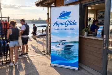 Ролл-ап Royal з округлою краплеподібною основою, розмір 100×200 см, у пункті прокату човнів на міському причалі.