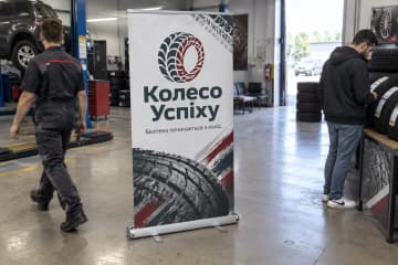 Ролл-ап Royal Plus 150×200 см стоїть у шинному сервісі поруч зі стосами шин і робочою зоною.