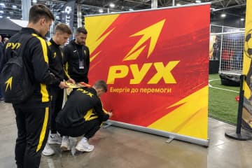 На фото ролл-ап Grand розміром 240×200 см у спортивній зоні поруч із футбольним майданчиком.
