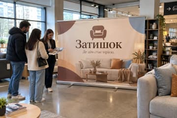 На фото ролл-ап Grand розміром 240×200 см у салоні меблів серед диванів і полиць.