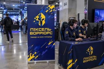 На фото ролл-ап Classic розміром 100×200 см стоїть у зоні кіберспорту на техконференції, видно алюмінієву касету та дві поворотні ніжки.