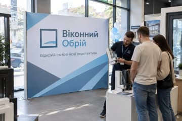 На фото П-подібний текстильний стенд Тексвол у салоні віконного бренду, поруч стоять зразки профілів і відвідувачі.
