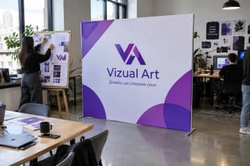 На фото текстильний стенд Тексвол 250×200 см у дизайн-студії під час відкритого дня, на передньому плані видно робочий стіл.