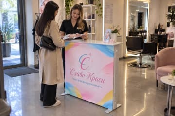 На фото промостіл Textile розміром 100×35 см у зоні рецепції салону краси.