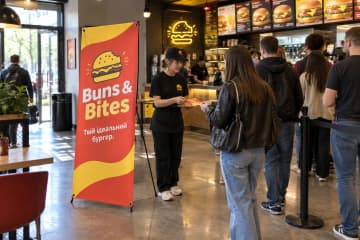 Х-банер Junior 80×180 см для бургерної Buns & Bites біля каси в залі закладу.