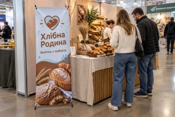Х-банер Prime 60×160 см у пекарні на продуктовому ярмарку біля столу з випічкою та покупцями.