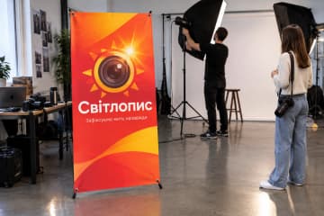 Х-банер Classic 120×200 см у фотостудії поруч із софтбоксами, камерою та фоном.