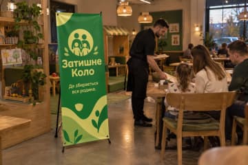 Х-банер Classic 80×180 см у сімейному ресторані біля столів і дитячого куточка.