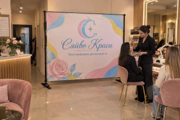 Брендвол Cross розміщено у салоні краси Сяйво Краси біля робочих місць і ресепшена, а стійки на Х-подібних опорах добре видно на підлозі.