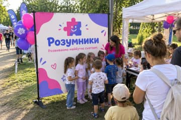 Брендвол Cross 200×200 см встановлено на сімейному фестивалі Розумники біля дитячої зони та столу для майстер-класів, а стійки на Х-подібних опорах видно поруч.