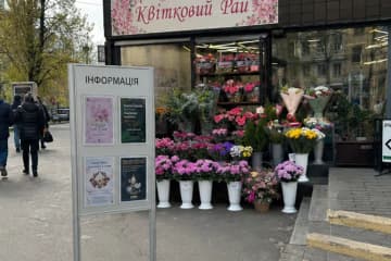 Інформаційний стенд на ніжці з кишенями біля квіткового магазину