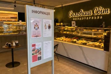 Підлоговий інформаційний стенд з кишенями в кондитерській