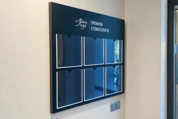 Темно-синій настінний стенд з шістьма кишенями в стоматологічній клініці