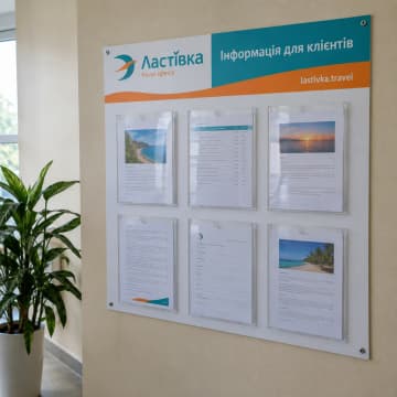Настінний інформаційний стенд з шістьма кишенями А4 в офісі турагенції