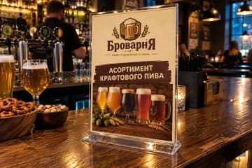 Менюхолдер з асортиментом пива на барній стійці пабу
