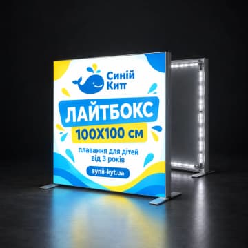 Мобільний лайтбокс з LED-підсвіткою на темному тлі, поруч каркас без полотна
