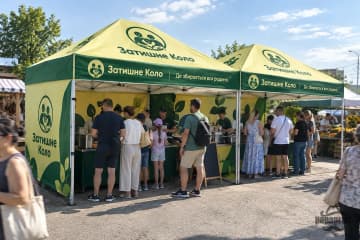 Два шатри з друком на фермерському ярмарку, біля прилавків черга