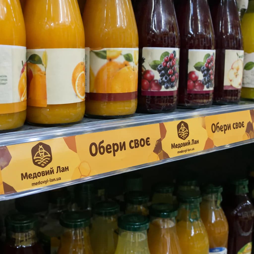 Шелфтокер з логотипом на полиці з соками